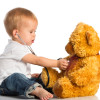 baby plays in doctor toy bear and stethoscope