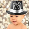 One year old baby boy wearing a Happy New Year top hat.