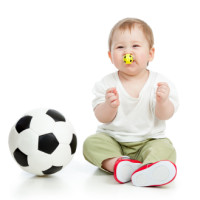 adorable baby football player with ball and whistle over white b